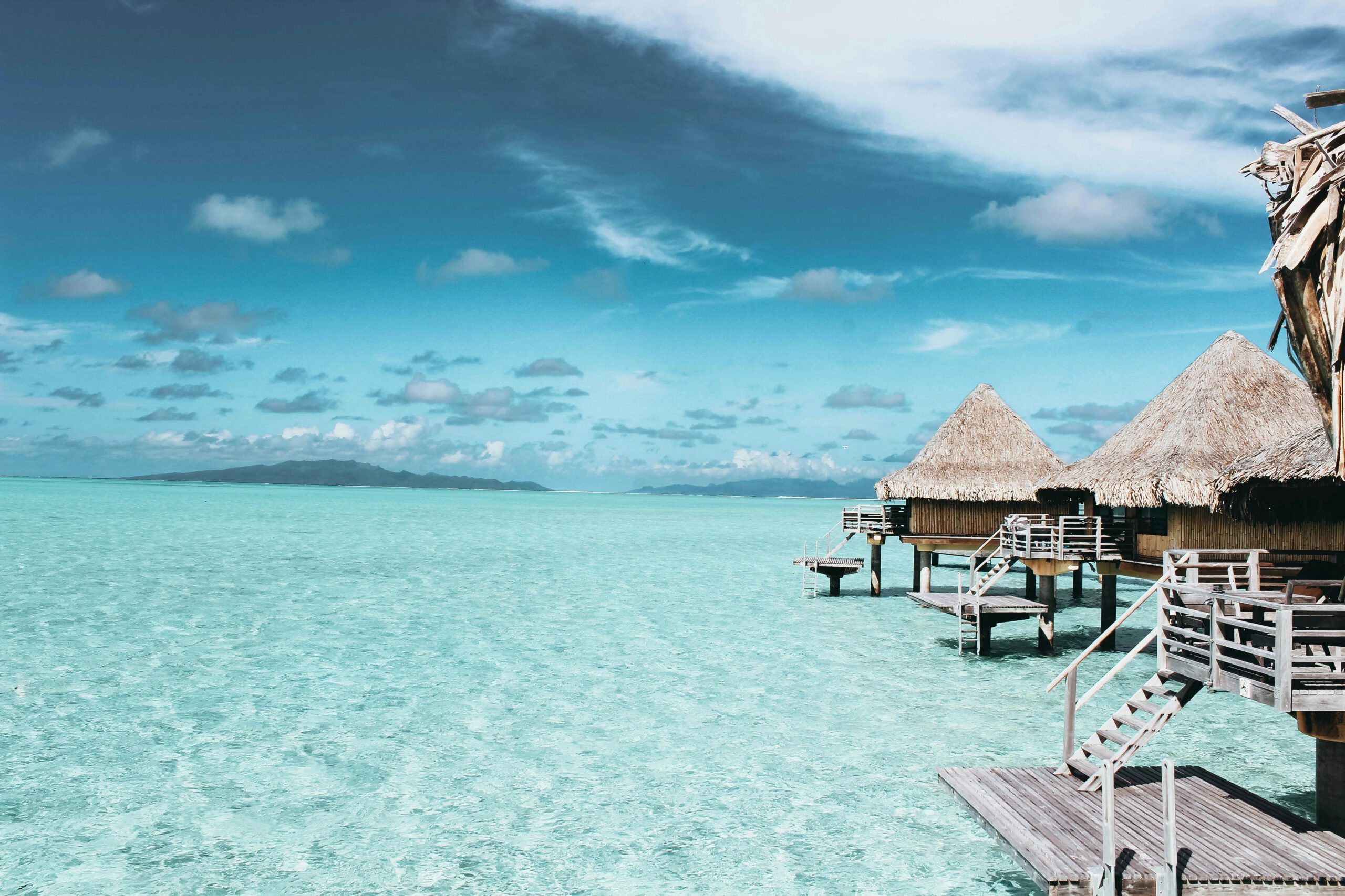 Overwater bungalows on a crystal-clear turquoise sea in French Polynesia.